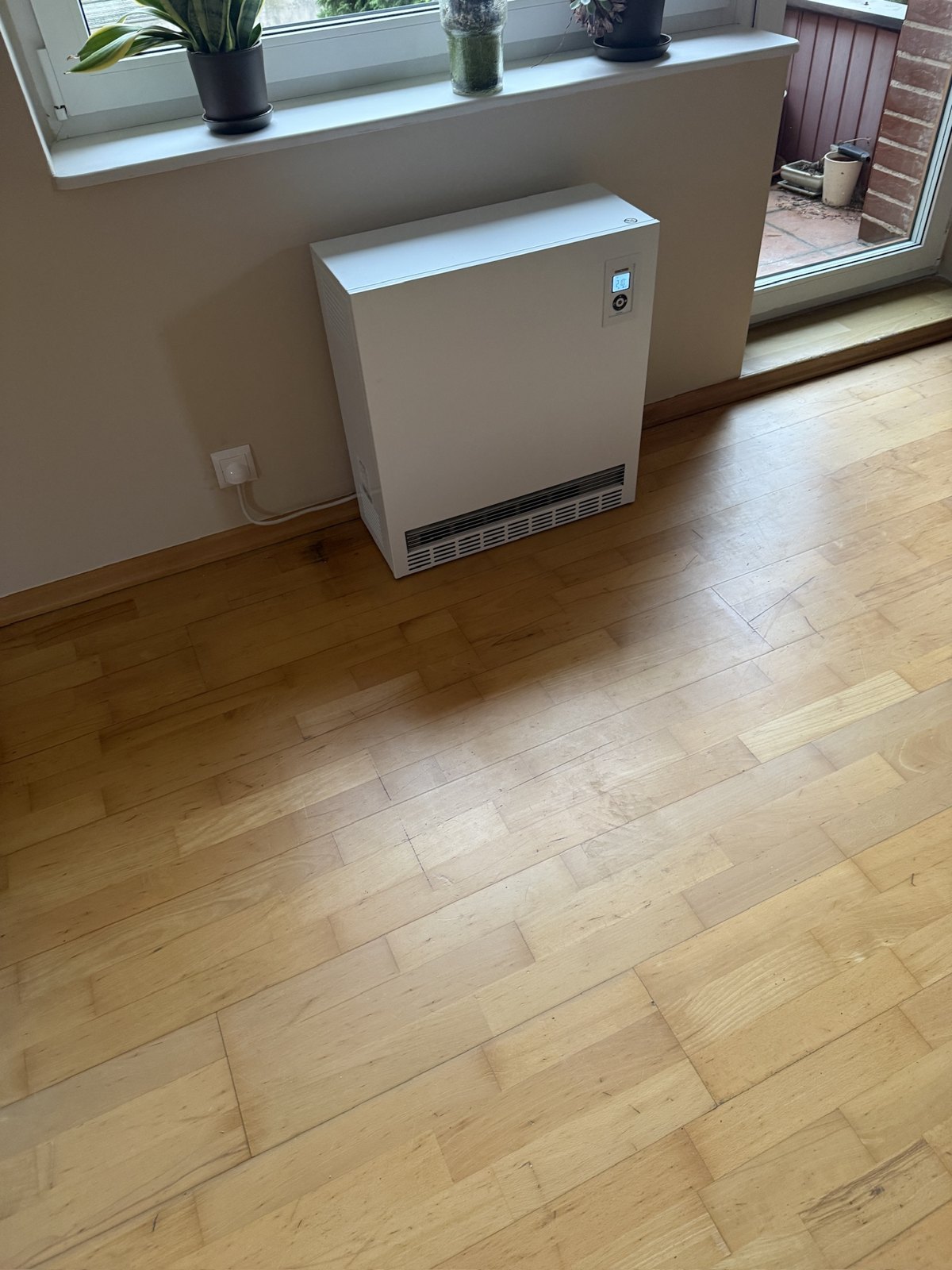 Kompaktowy piec STIEBEL ELTRON SHF ustawiony pod oknem